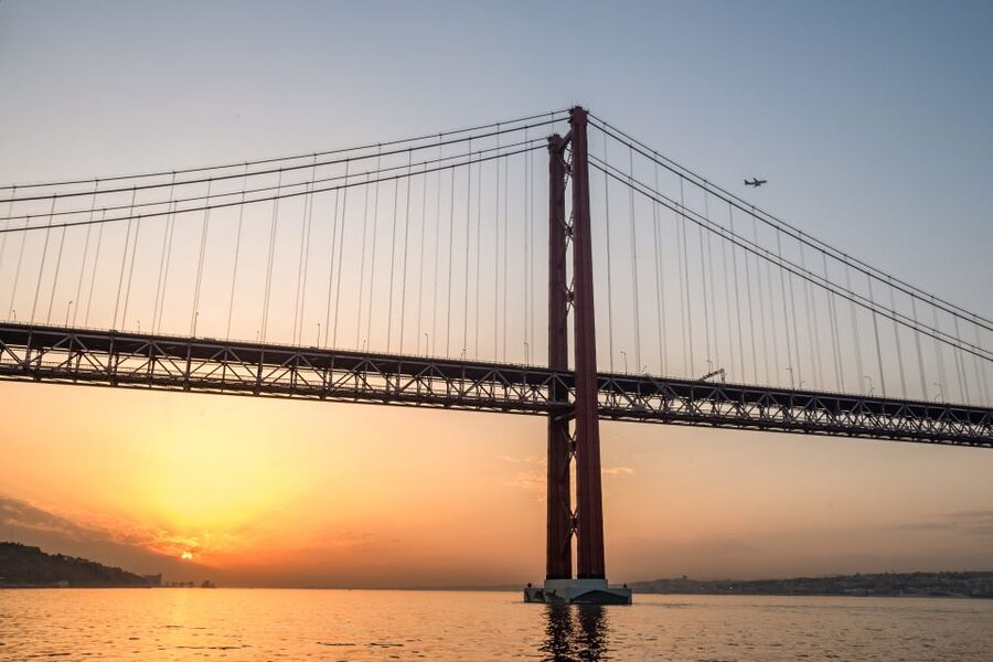 Lisbon: Private Sunset Cruise on the Tagus River with Drink - Sailing under the 25 de Abril Bridge, with Alcântara rolling by